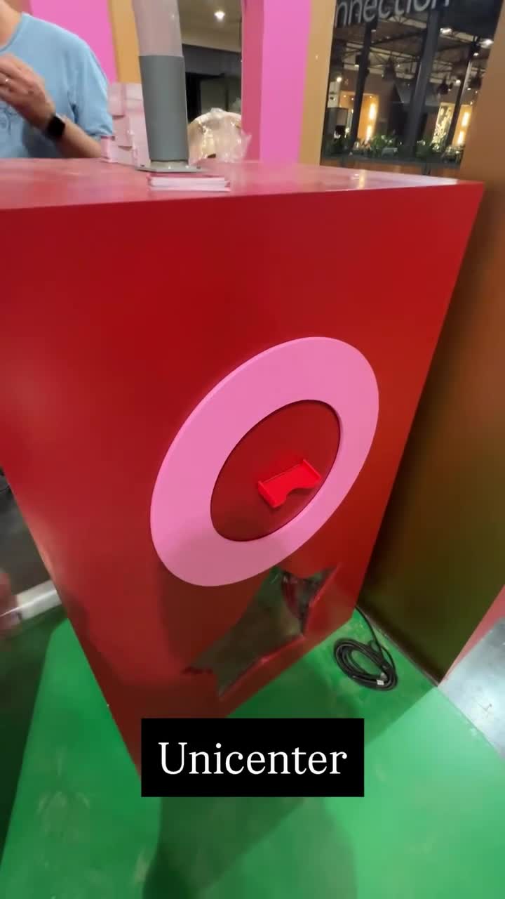 Dispositivo rojo y rosa que entrega tarjetas en una activación de Unicenter